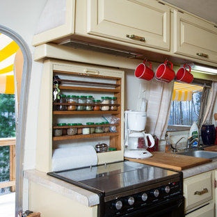 На фото: маленькие линейные кухни в стиле фьюжн с кладовкой, двойной раковиной, фасадами с выступающей филенкой, бежевыми фасадами, столешницей из ламината, бежевым фартуком, техникой под мебельный фасад и ковровым покрытием без острова