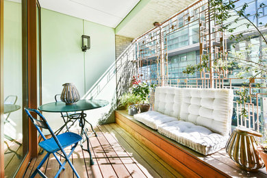 Ejemplo de terraza moderna en anexo de casas con jardín de macetas y barandilla de metal