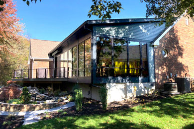 Photo of a mid-sized contemporary one-storey black house exterior in Louisville with concrete fiberboard siding, a shed roof and a shingle roof.