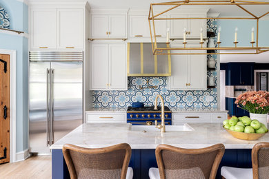 Eat-in kitchen - large mediterranean l-shaped porcelain tile and brown floor eat-in kitchen idea in Philadelphia with a farmhouse sink, shaker cabinets, white cabinets, quartzite countertops, blue backsplash, cement tile backsplash, stainless steel appliances, an island and beige countertops
