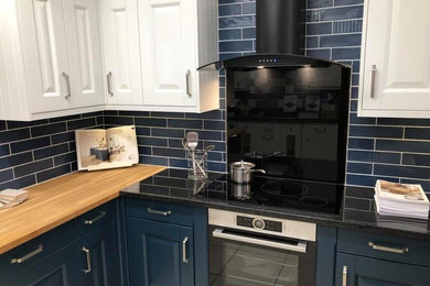 Photo of a kitchen in Other with wood worktops and black splashback.