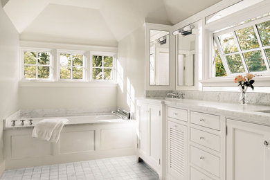 Inspiration for a traditional master bathroom in DC Metro with an undermount sink, white cabinets, marble benchtops, an undermount tub, white tile, stone tile, white walls, marble floors, recessed-panel cabinets and white benchtops.