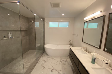 Example of a large trendy master gray tile and ceramic tile marble floor, white floor and double-sink bathroom design in Los Angeles with flat-panel cabinets, brown cabinets, a one-piece toilet, white walls, a drop-in sink, marble countertops, white countertops, a niche and a floating vanity