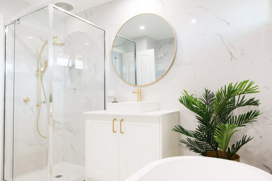 Inspiration for a mid-sized traditional master bathroom in Melbourne with shaker cabinets, white cabinets, a freestanding tub, a corner shower, black and white tile, porcelain tile, white walls, porcelain floors, a vessel sink, laminate benchtops, white floor, a hinged shower door, white benchtops, a single vanity and a built-in vanity.