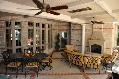 Mid-sized transitional backyard concrete paver patio photo with a fireplace and a roof extension