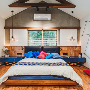 Esempio di una camera da letto etnica con pareti bianche, pavimento in legno massello medio e pavimento marrone