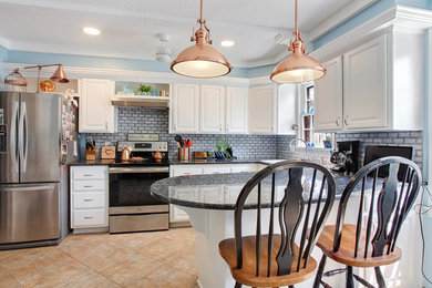 Elegant terra-cotta tile eat-in kitchen photo in Kansas City with white cabinets, granite countertops and black countertops