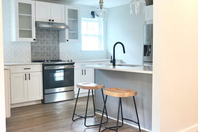 Small cottage u-shaped laminate floor enclosed kitchen photo in Charleston with quartzite countertops, white backsplash, ceramic backsplash, stainless steel appliances, an island and white countertops