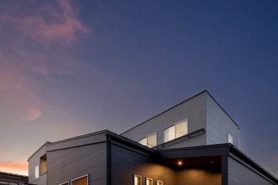 Diseño de fachada de casa gris y negra minimalista de tamaño medio de dos plantas con revestimientos combinados, tejado de un solo tendido y tejado de metal