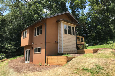Imagen de fachada de casa marrón minimalista de tamaño medio de dos plantas con tejado a dos aguas y tejado de metal