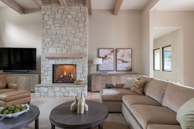 Inspiration for a large transitional light wood floor and exposed beam living room remodel in Portland with beige walls, a standard fireplace, a stacked stone fireplace and a wall-mounted tv