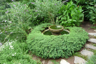 Design ideas for a mid-sized traditional backyard full sun garden in New York with a water feature.