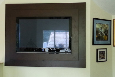 Imagen de cine en casa abierto tradicional de tamaño medio con paredes amarillas y televisor colgado en la pared