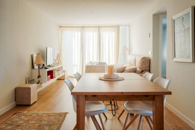 Modelo de comedor actual de tamaño medio cerrado con paredes beige, suelo de madera clara y suelo beige