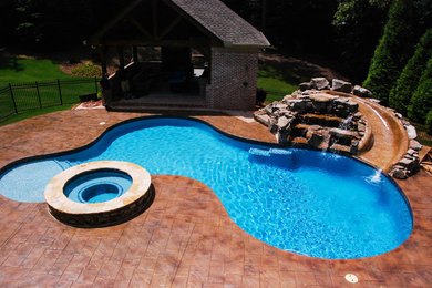 Design ideas for a mid-sized contemporary backyard custom-shaped pool in Atlanta with decking.