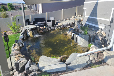 Inspiration for a huge full sun backyard stone and vinyl fence landscaping in Denver for spring.