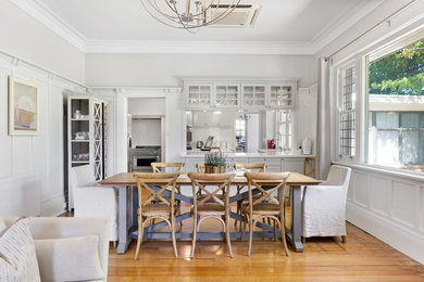 Inspiration for a mid-sized country open plan dining in Wollongong with white walls, light hardwood floors, no fireplace and beige floor.