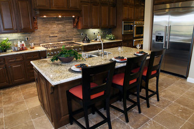 Example of a large dark wood floor eat-in kitchen design in San Francisco with dark wood cabinets, marble countertops, beige backsplash, mosaic tile backsplash, stainless steel appliances and an island