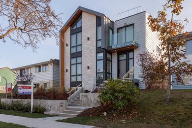 Large minimalist three-story mixed siding exterior home photo in Vancouver with a metal roof