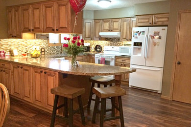 Eat-in kitchen - mid-sized traditional u-shaped dark wood floor eat-in kitchen idea in Other with raised-panel cabinets, light wood cabinets, laminate countertops, multicolored backsplash, mosaic tile backsplash, white appliances, a peninsula and a double-bowl sink