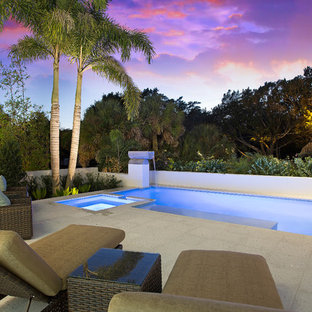 Mittelgroßer Moderner Schwimmteich hinter dem Haus in rechteckiger Form mit Wasserspiel und Betonplatten in Tampa