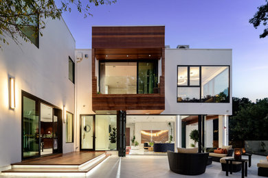 Diseño de fachada de casa blanca contemporánea extra grande de dos plantas con revestimiento de estuco y tejado plano
