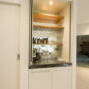 Mid-sized contemporary kitchen pantry designs - Inspiration for a mid-sized contemporary galley ceramic floor kitchen pantry remodel in Napier-Hastings with a double-bowl sink, white cabinets, granite countertops, white backsplash, glass sheet backsplash, stainless steel appliances and an island