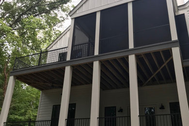 This is an example of a mid-sized contemporary screened-in back porch design in Other with decking.