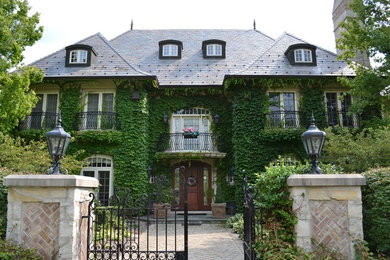 Traditional three-story stucco exterior home idea in Milwaukee with a hip roof