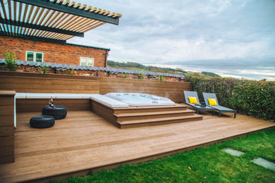 Design ideas for a medium sized contemporary back rectangular above ground hot tub in Other with decking.