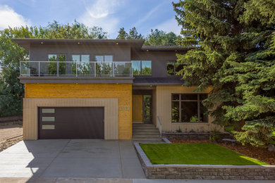 Inspiration for a mid-sized modern two-storey stucco grey exterior in Calgary with a hip roof.