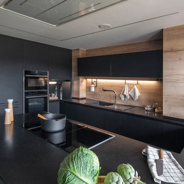 Negro y madera: una elegante cocina con península