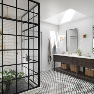 Example of a country white tile and subway tile corner shower design in San Francisco with furniture-like cabinets, dark wood cabinets, white walls, an undermount sink and a hinged shower door