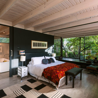This is an example of a large contemporary master bedroom in Other with black walls, laminate floors and no fireplace.