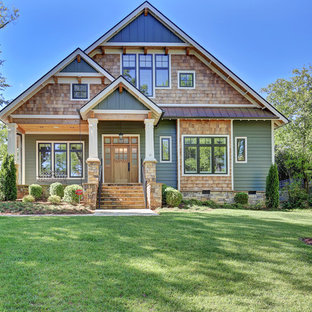 Новые идеи обустройства дома: двухэтажный фасад частного дома среднего размера зеленого цвета в стиле кантри с комбинированной облицовкой и двускатной крышей