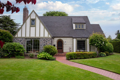 Large transitional green stone and shingle exterior home idea in Portland