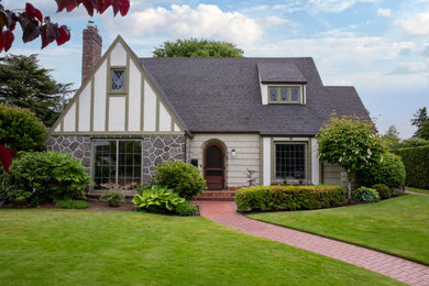 Modelo de fachada de casa verde clásica renovada grande con revestimiento de piedra y teja