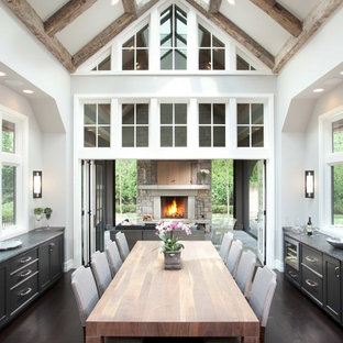Example of a large transitional dark wood floor and brown floor kitchen/dining room combo design in Minneapolis with white walls, a standard fireplace and a stone fireplace