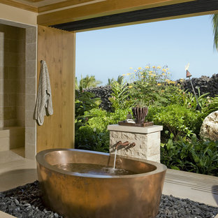 Ispirazione per una stanza da bagno tropicale con vasca freestanding, piastrelle beige e doccia alcova