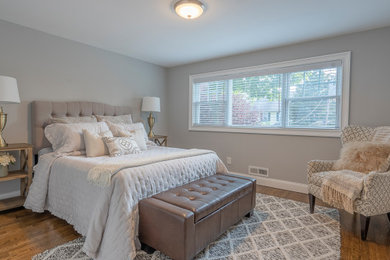 Bedroom - mid-sized modern guest medium tone wood floor and brown floor bedroom idea in New York with gray walls
