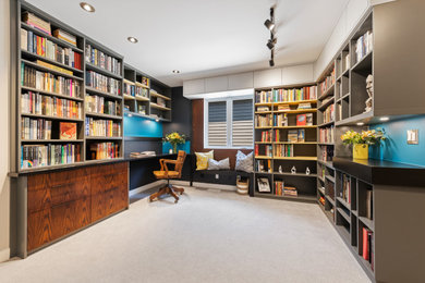 Imagen de despacho retro de tamaño medio sin chimenea con biblioteca, paredes multicolor, moqueta, escritorio empotrado, suelo gris y madera