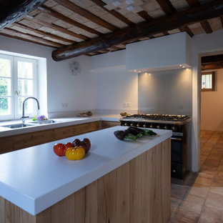 Пример оригинального дизайна интерьера: маленькая отдельная, угловая кухня в стиле современная классика с врезной раковиной, фасадами с декоративным кантом, светлыми деревянными фасадами, столешницей из кварцевого композита, фартуком цвета металлик, фартуком из металлической плитки, черной техникой, полом из терракотовой плитки, островом, розовым полом и белой столешницей