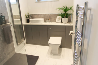 Inspiration for a small modern grey and white ensuite bathroom in Other with flat-panel cabinets, grey cabinets, a built-in shower, a one-piece toilet, grey tiles, white walls, vinyl flooring, a vessel sink, marble worktops, white floors, an open shower, white worktops, an enclosed toilet, a single sink and a built in vanity unit.