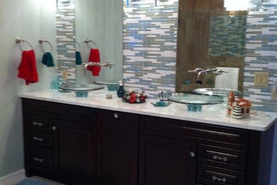 Bathroom - transitional blue tile and mosaic tile bathroom idea in Philadelphia with a vessel sink, raised-panel cabinets, dark wood cabinets and quartz countertops