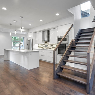Small modern kitchen pantry pictures - Inspiration for a small modern single-wall dark wood floor kitchen pantry remodel in Edmonton with a drop-in sink, flat-panel cabinets, white cabinets, quartzite countertops, multicolored backsplash, glass tile backsplash, stainless steel appliances and an island
