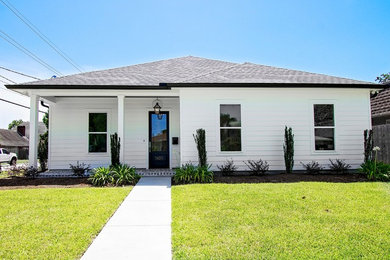 Transitional white one-story concrete fiberboard house exterior idea in New Orleans with a hip roof and a shingle roof