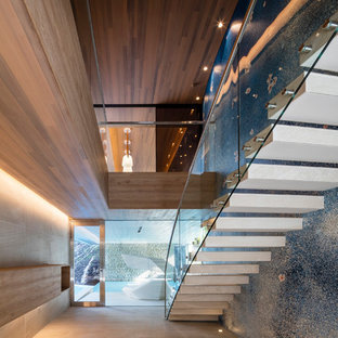 他の地域のコンクリートのコンテンポラリースタイルのおしゃれな階段 (ガラスの手すり) の写真