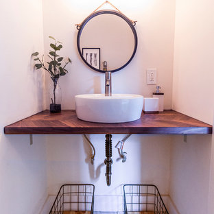 Idee per una piccola stanza da bagno con doccia minimalista con nessun'anta, ante nere, pareti bianche, pavimento in laminato, lavabo a bacinella, top in legno, pavimento beige, top marrone, vasca ad alcova, vasca/doccia, WC a due pezzi, piastrelle bianche, piastrelle in gres porcellanato e doccia con tenda