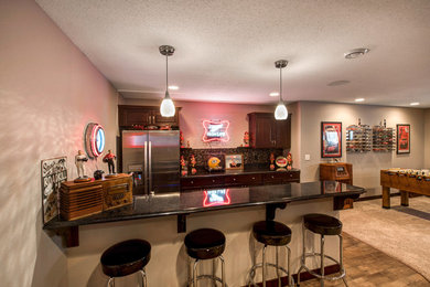 Example of a large classic galley light wood floor seated home bar design in Other with an undermount sink, raised-panel cabinets, dark wood cabinets, granite countertops and multicolored backsplash