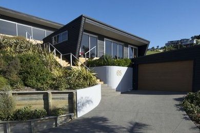 Photo of a small contemporary black exterior in Hamilton with wood siding.